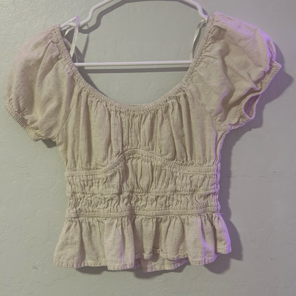 cute cream flowy top with a bust underline and puffy sleeves and a slight crop